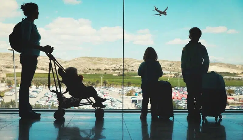 A mom waiting with baby stroller bag for her flight