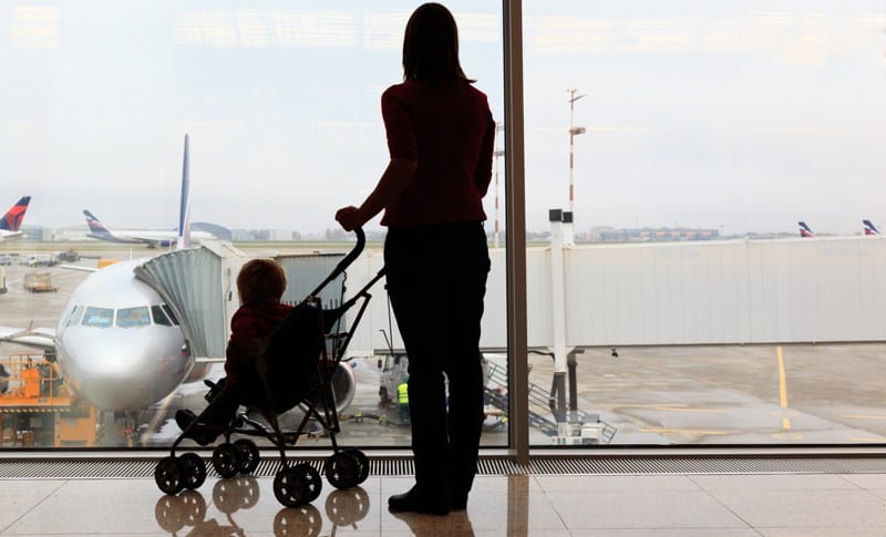 A baby on a stroller with mom for flying