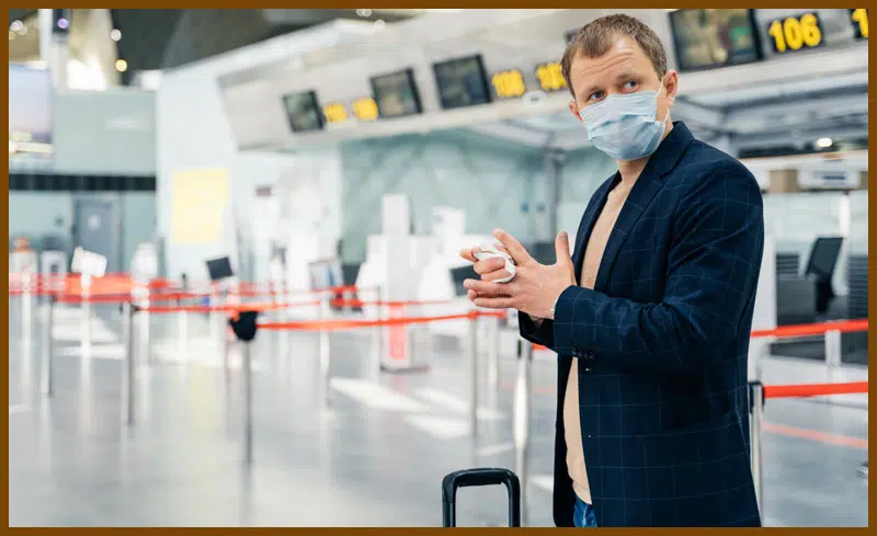 A traveler clean his hand by using antibacterial wipes in the airport