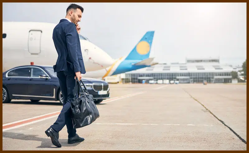 Traveler carrying a duffel bag while walking outside airport